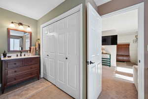 Bathroom featuring tile patterned flooring, wooden walls, and vanity