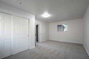 Unfurnished bedroom with a closet and light carpet