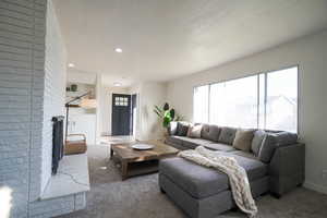 Living room with a brick fireplace and carpet floors