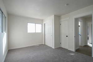 Unfurnished bedroom featuring dark colored carpet