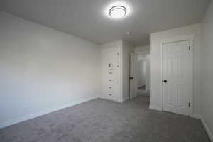 Unfurnished bedroom with carpet flooring and a textured ceiling