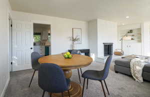 Carpeted dining space with a fireplace