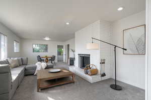 Carpeted living room featuring a brick fireplace