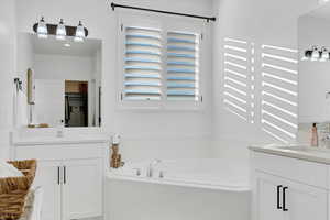 Bathroom featuring a bathing tub and vanity