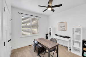 Bedroom used as office with ceiling fan and light colored carpet