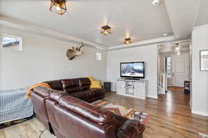 Living room featuring a textured ceiling, hardwood / wood-style floors, and a tray ceiling