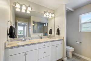 Bathroom featuring toilet, vanity, and tile patterned flooring