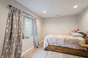 Bedroom with light hardwood / wood-style flooring