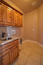 Washroom featuring sink, cabinets, and hookup for a washing machine