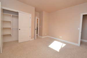 Unfurnished bedroom with a closet and light carpet