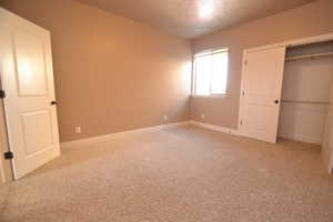 Unfurnished bedroom with a closet and carpet flooring