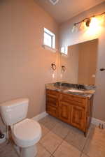 Bathroom with toilet, tile patterned flooring, and vanity