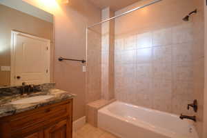 Bathroom with vanity, tile patterned floors, and washtub / shower combination