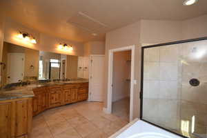 Bathroom with vanity, tile patterned floors, and independent shower and bath