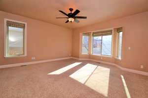 Unfurnished room featuring ceiling fan and carpet floors