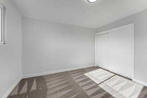 Unfurnished bedroom with a closet and carpet floors