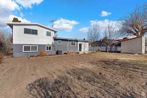 Rear view of property featuring central AC unit and a yard