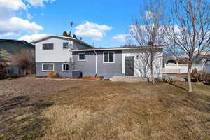 Back of house with cooling unit and a yard