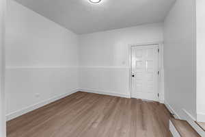 Spare room with a textured ceiling and light wood-type flooring