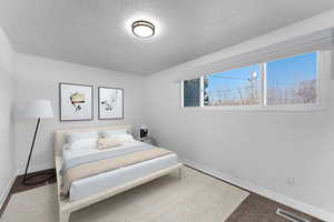 Bedroom featuring carpet floors and a textured ceiling