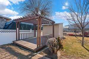 Deck featuring a lawn and a pergola