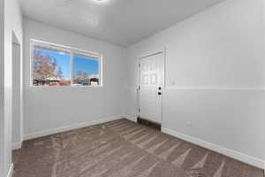 Carpeted empty room with a textured ceiling