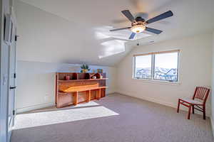 Bedroom featuring ceiling fan, lofted ceiling, and light carpet