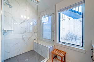 Bathroom featuring a shower with door and vanity