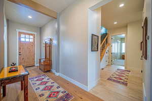 Entryway featuring beamed ceiling, a healthy amount of sunlight, and light wood-type flooring