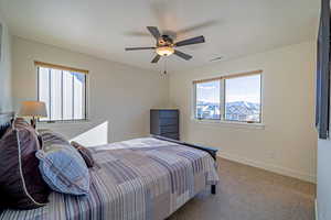 Bedroom with ceiling fan and light carpet