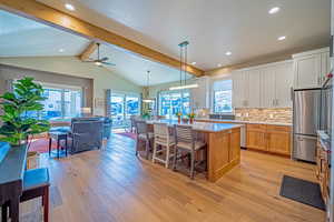 Kitchen featuring pendant lighting, a center island, ceiling fan, appliances with stainless steel finishes, and white cabinetry