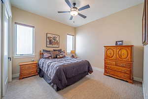 Bedroom with ceiling fan and light carpet