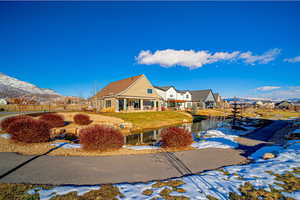 View of front of home with a mountain view and a yard