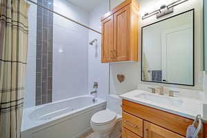 Full bathroom featuring shower / tub combo with curtain, vanity, and toilet