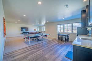 Rec room featuring sink and light wood-type flooring