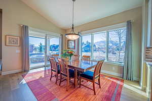 Dining space featuring a mountain view, light hardwood / wood-style flooring, and vaulted ceiling