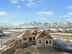 Snow covered back of property featuring a mountain view