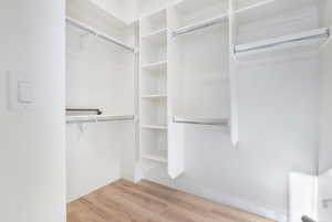 Spacious closet with hardwood / wood-style floors