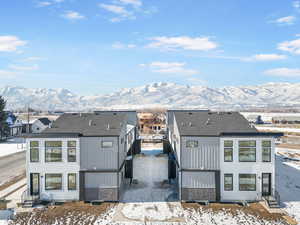 Snow covered rear of property featuring a mountain view