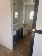 Bathroom with vanity, plenty of natural light, and toilet