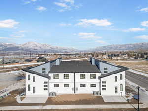 Back of house with central AC and a mountain view