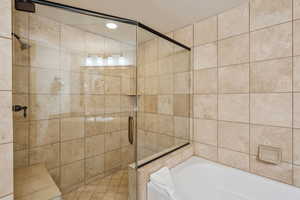 Bathroom featuring shower with separate bathtub