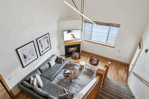 Living room with high vaulted ceiling and hardwood / wood-style floors