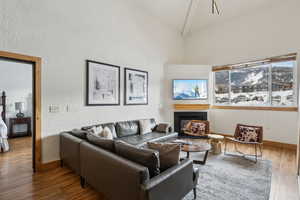 Living room with beam ceiling, high vaulted ceiling, and hardwood / wood-style flooring