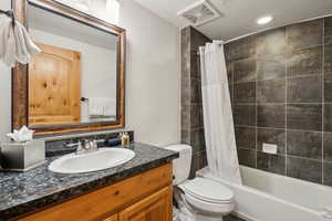 Full bathroom with toilet, vanity, and shower / bath combo with shower curtain