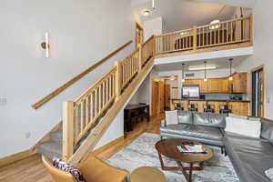 Living room featuring a towering ceiling and light hardwood / wood-style flooring