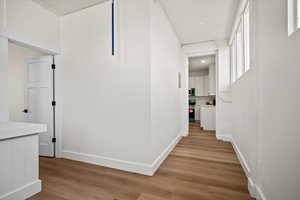 Hall with light hardwood / wood-style flooring