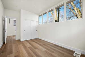 Unfurnished bedroom with light wood-type flooring and a closet