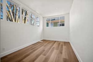 Empty room with light hardwood / wood-style flooring