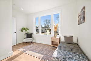 Bedroom featuring light wood-type flooring and multiple windows